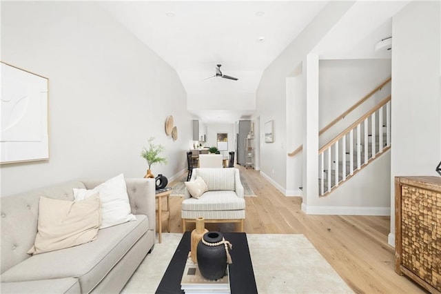 living room featuring light hardwood / wood-style flooring, ceiling fan, and vaulted ceiling