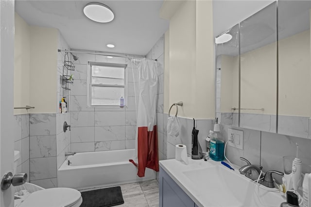 full bathroom featuring toilet, shower / bath combo with shower curtain, vanity, and tile walls