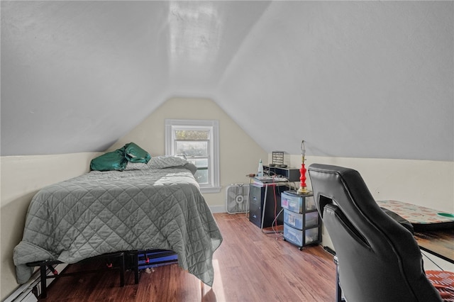 bedroom with wood-type flooring and vaulted ceiling