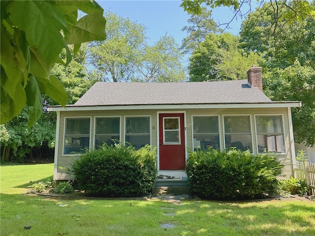 view of front of property featuring a sunroom and a front yard