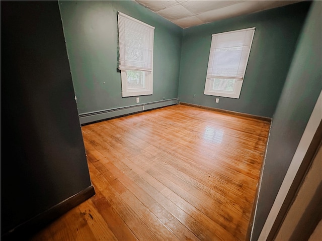 empty room featuring a baseboard radiator and light wood-type flooring