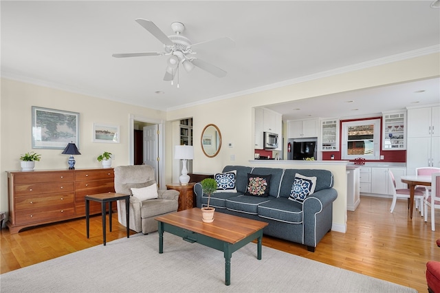 living room with light hardwood / wood-style floors, ceiling fan, and crown molding