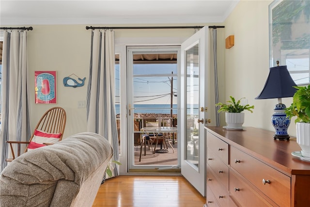 doorway with crown molding and light hardwood / wood-style floors