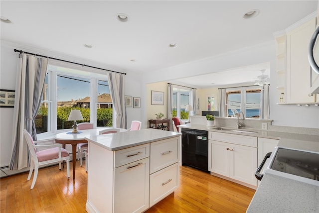 kitchen featuring black dishwasher, light hardwood / wood-style floors, white cabinetry, and sink