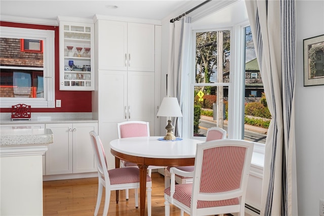 dining area with baseboard heating, plenty of natural light, and light hardwood / wood-style flooring