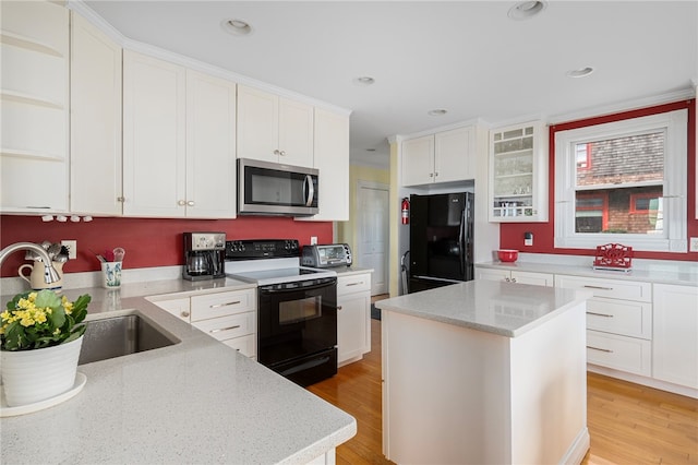 kitchen featuring a center island, white cabinets, black appliances, and light hardwood / wood-style floors