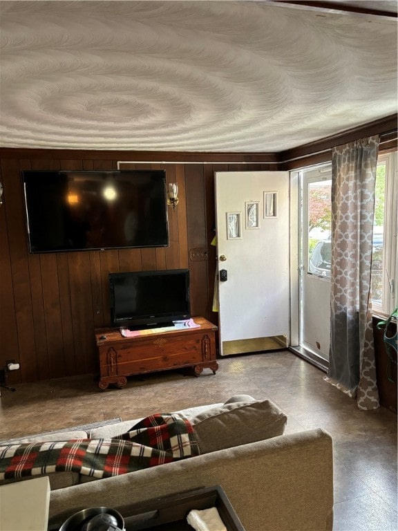 living room featuring wood walls and crown molding