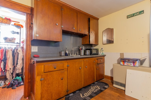 kitchen featuring decorative backsplash, wood-type flooring, and sink