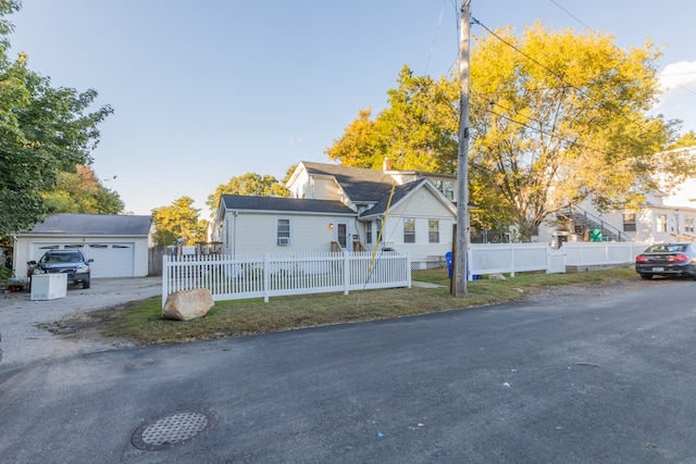 view of front of home featuring a garage and an outbuilding