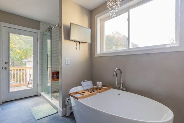 bathroom with tile patterned flooring, separate shower and tub, and sink