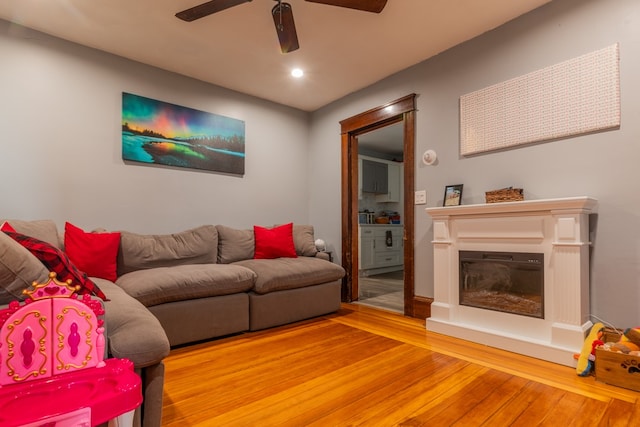 living room with hardwood / wood-style flooring and ceiling fan