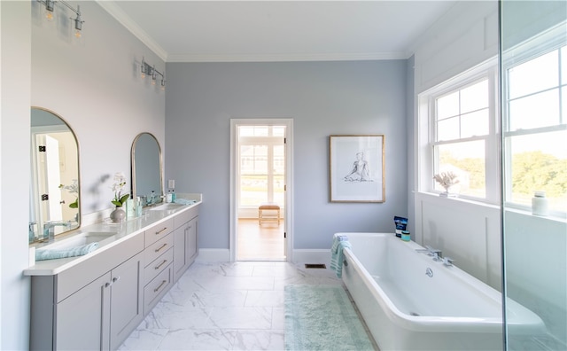 bathroom with a wealth of natural light, ornamental molding, vanity, and a bathing tub