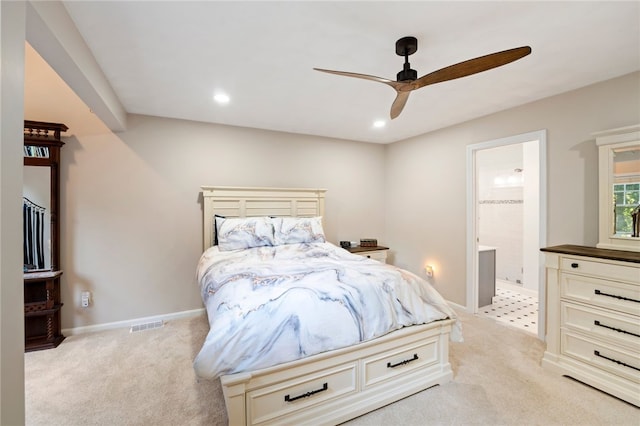 bedroom with light carpet, ensuite bath, and ceiling fan