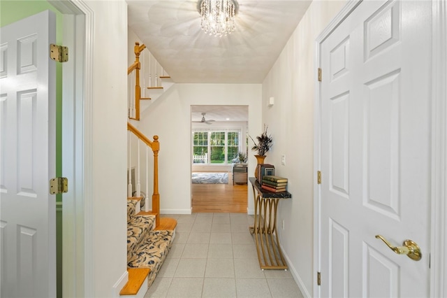 foyer entrance with ceiling fan with notable chandelier and light tile patterned floors