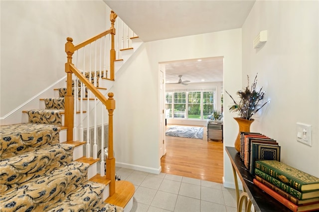 staircase with ceiling fan and hardwood / wood-style floors