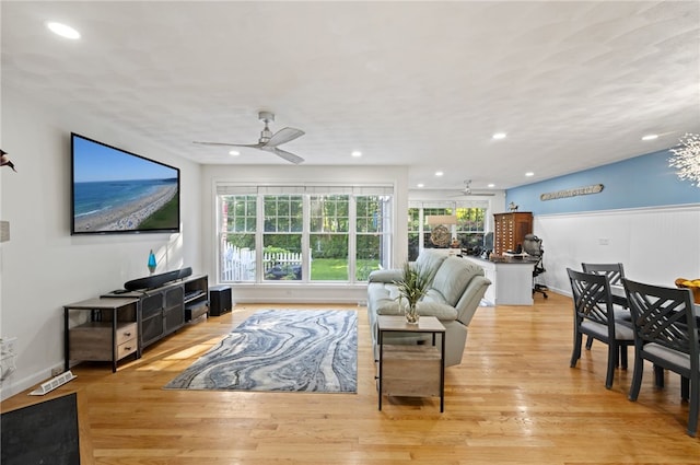 living room featuring a healthy amount of sunlight, ceiling fan, and light hardwood / wood-style flooring