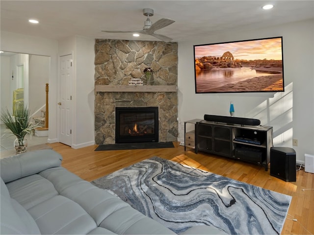 living room with wood-type flooring, a fireplace, and ceiling fan