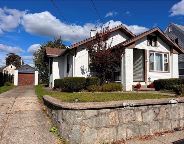 bungalow featuring an outbuilding, a front lawn, and a garage