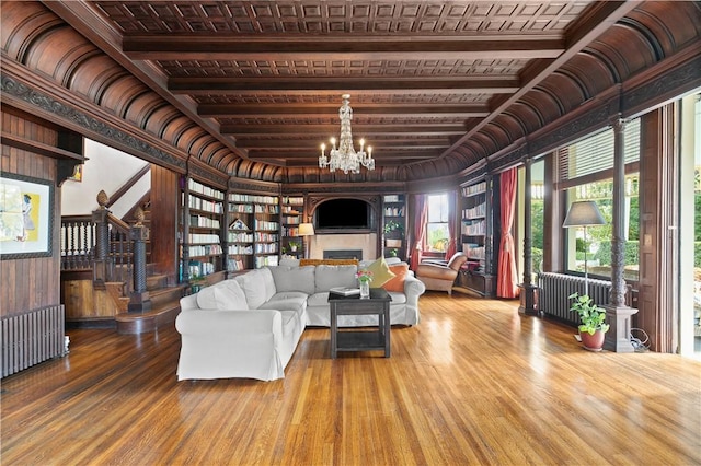 68 Kay St, Newport, RI 02840 - living room with a fireplace, wood walls, wood finished floors, a chandelier, and radiator heating unit
