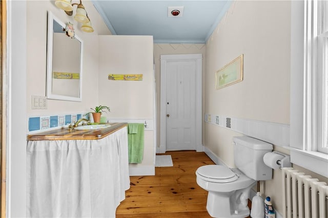 68 Kay St, Newport, RI 02840 - bathroom featuring ornamental molding, radiator, wood finished floors, toilet, and a wainscoted wall