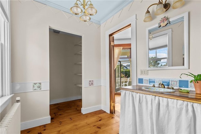 68 Kay St, Newport, RI 02840 - interior space with crown molding, radiator, baseboards, light wood-type flooring, and a notable chandelier