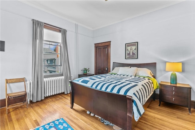 68 Kay St, Newport, RI 02840 - bedroom with crown molding, radiator heating unit, and light wood-style flooring