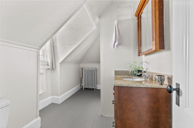 68 Kay St, Newport, RI 02840 - half bathroom with vanity, toilet, baseboards, radiator heating unit, and vaulted ceiling