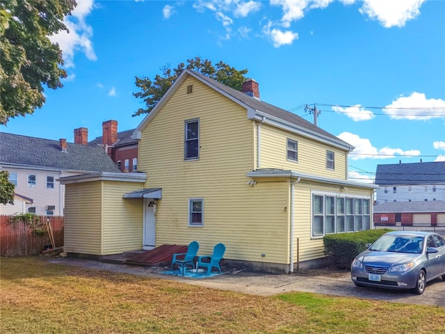 rear view of property featuring a yard