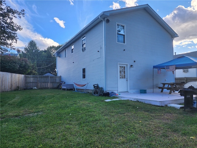 back of property with a lawn and a patio