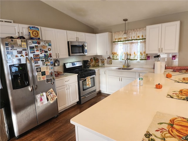 kitchen featuring white cabinets, lofted ceiling, sink, appliances with stainless steel finishes, and dark hardwood / wood-style flooring