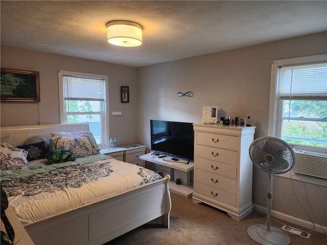 bedroom with multiple windows, cooling unit, and carpet floors