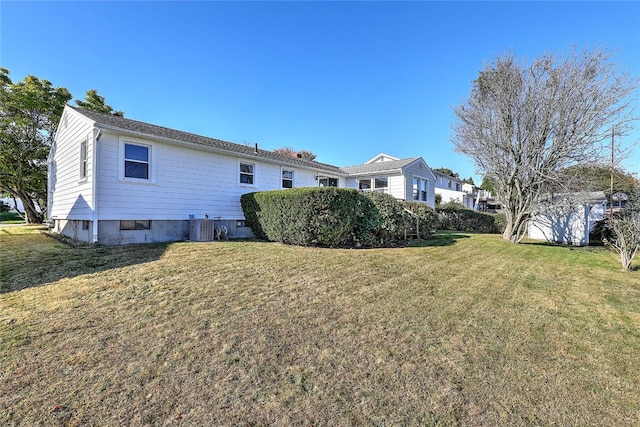 view of property exterior with central AC and a lawn