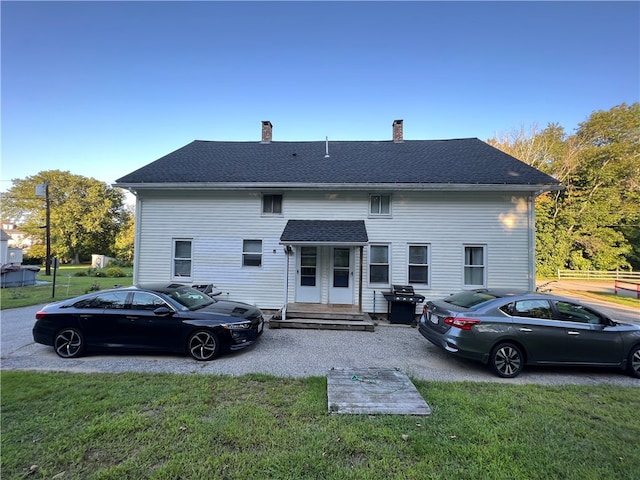 rear view of house featuring a lawn