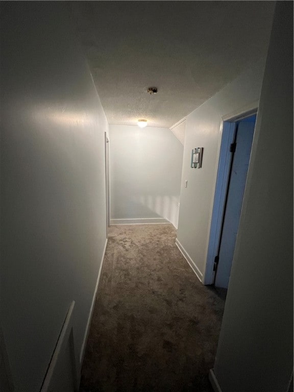 corridor featuring carpet floors and vaulted ceiling