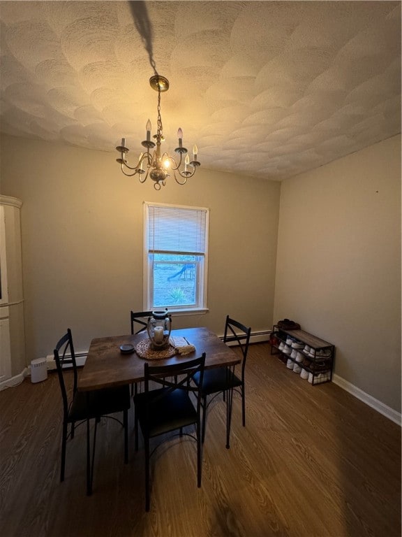 dining area featuring baseboard heating, a notable chandelier, and dark hardwood / wood-style floors