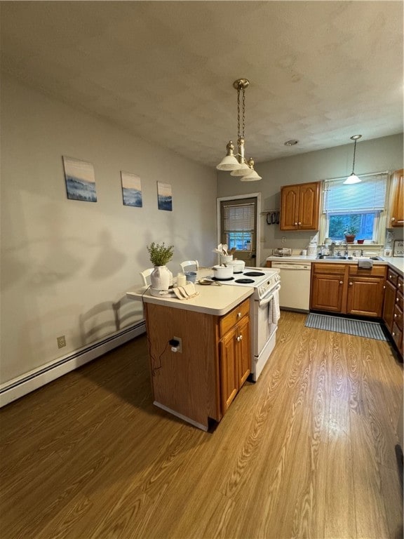 kitchen featuring a baseboard radiator, light wood-type flooring, pendant lighting, a center island, and white appliances