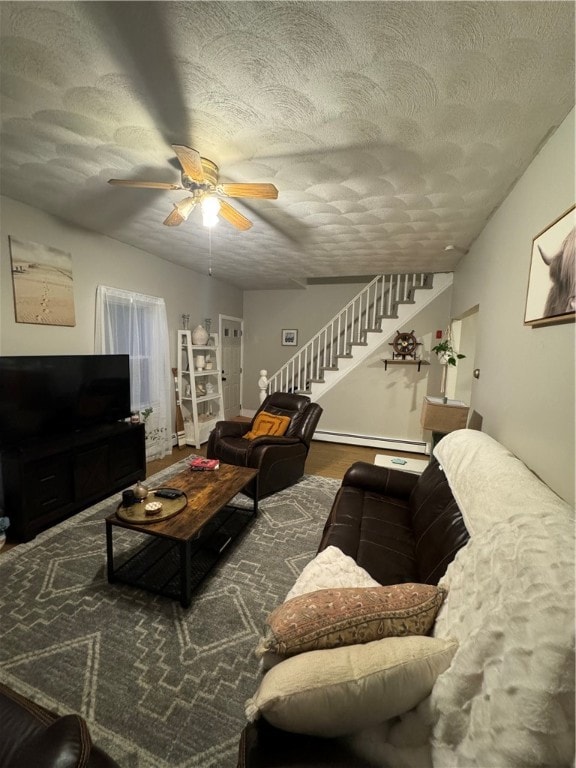 living room featuring ceiling fan, a textured ceiling, and baseboard heating