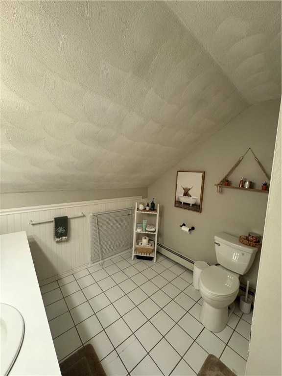 bathroom featuring toilet, baseboard heating, vaulted ceiling, vanity, and a textured ceiling