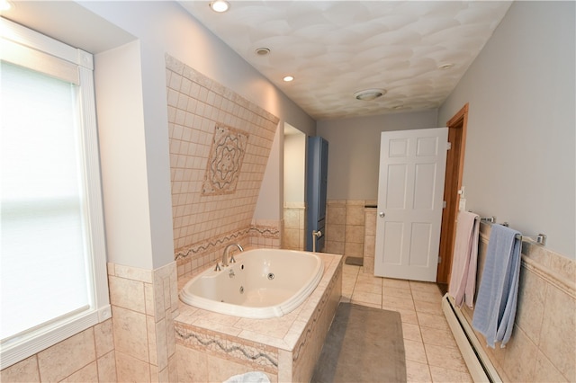 bathroom with a baseboard heating unit, tile patterned flooring, and tiled bath