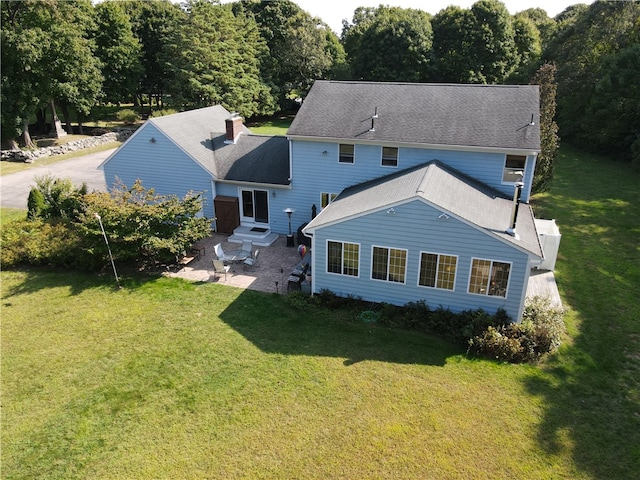 rear view of house featuring a lawn and a patio area