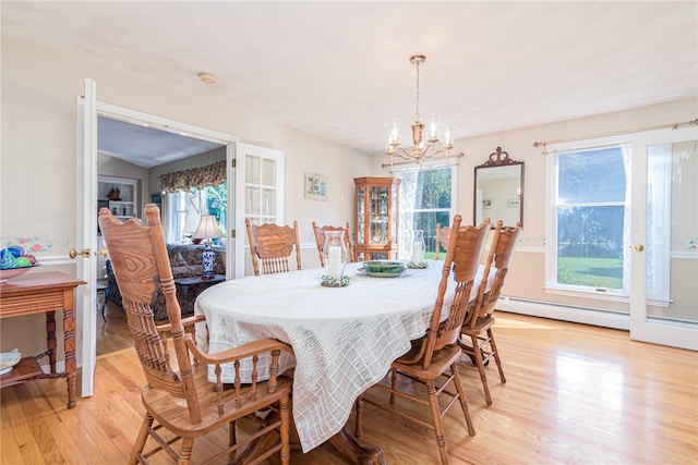 dining space featuring light wood-type flooring, baseboard heating, and a chandelier