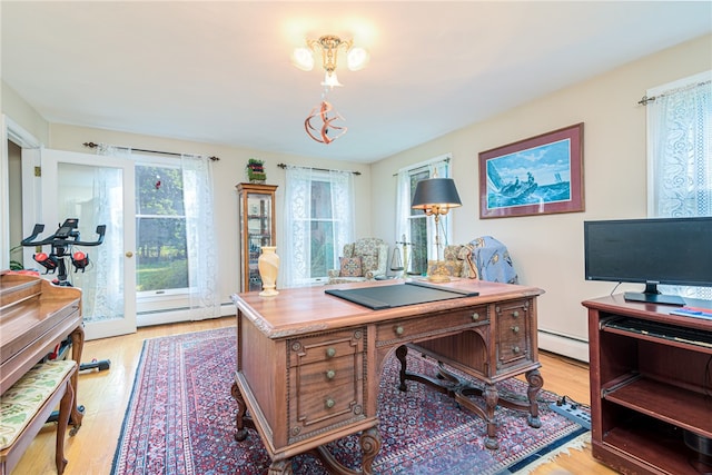 office space with a baseboard heating unit and light hardwood / wood-style flooring