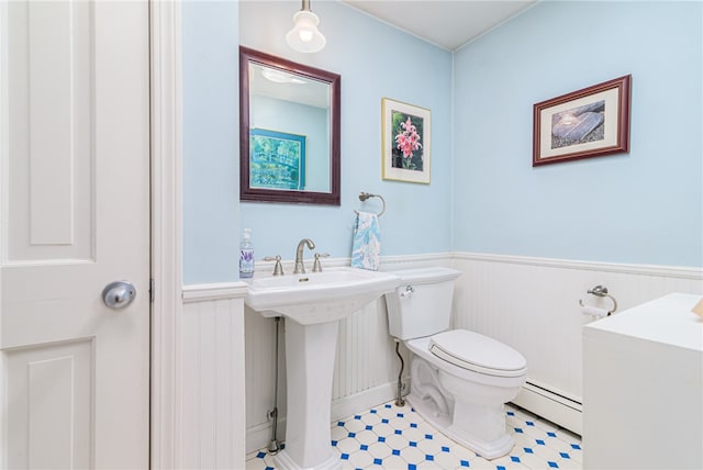 bathroom with toilet, a baseboard heating unit, sink, and tile patterned flooring