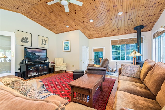 living room featuring ceiling fan, wooden ceiling, a wood stove, and vaulted ceiling