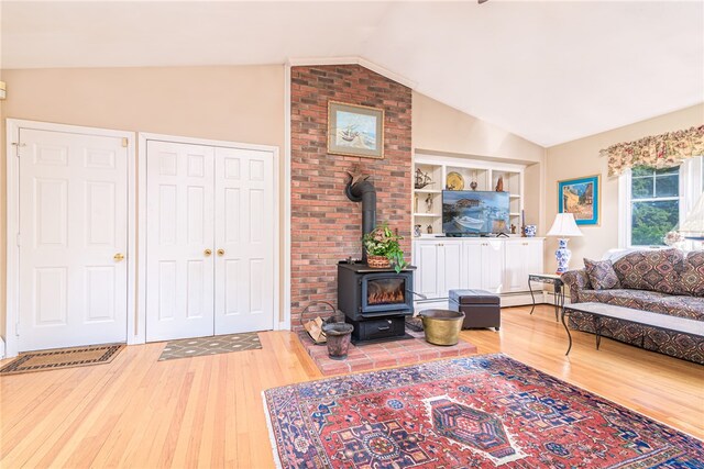 living room with lofted ceiling, wood-type flooring, built in features, a wood stove, and a baseboard radiator