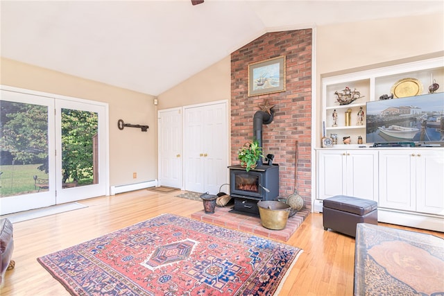 living room with a wood stove, vaulted ceiling, baseboard heating, and light wood-type flooring