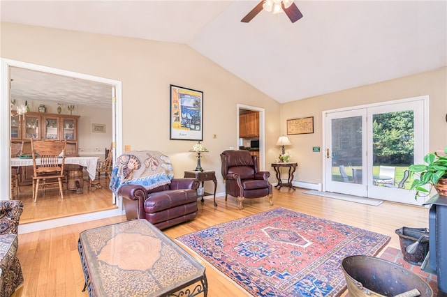 living room with lofted ceiling, ceiling fan, hardwood / wood-style flooring, and a baseboard heating unit