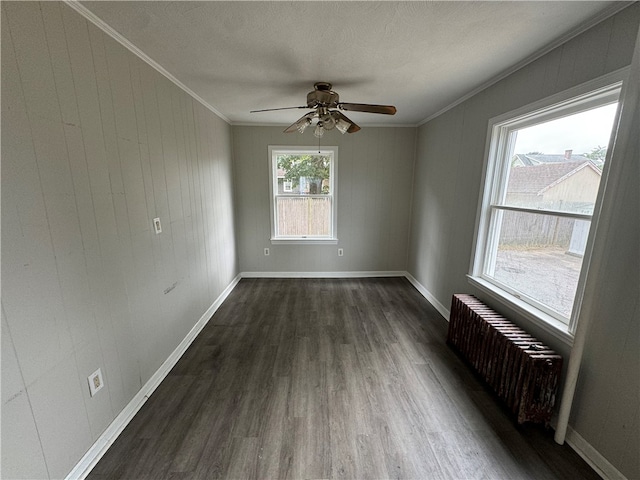 spare room with ornamental molding, radiator heating unit, dark wood-type flooring, and ceiling fan