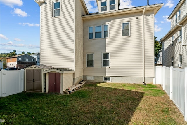 back of house with a storage shed and a yard