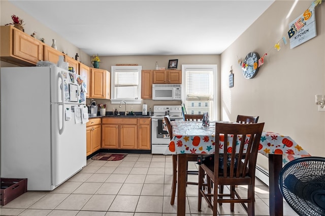 kitchen featuring a baseboard radiator, light brown cabinetry, light tile patterned flooring, sink, and white appliances